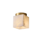 The Usilia alabaster ceiling light on a plain white background, warm honey-toned stone cube under a brass canopy.
