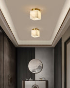 Two Usilia alabaster ceiling lights lit above a hallway console and round mirror, set into a tray ceiling.