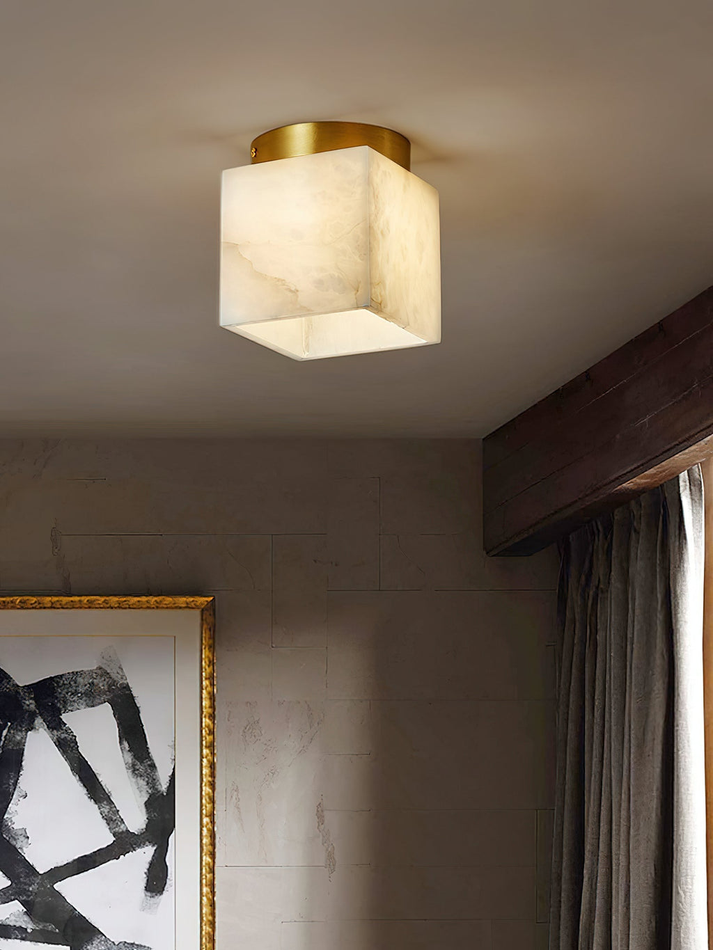 Usilia alabaster ceiling light lit close to camera in a plaster-walled room with a dark timber beam and curtain.