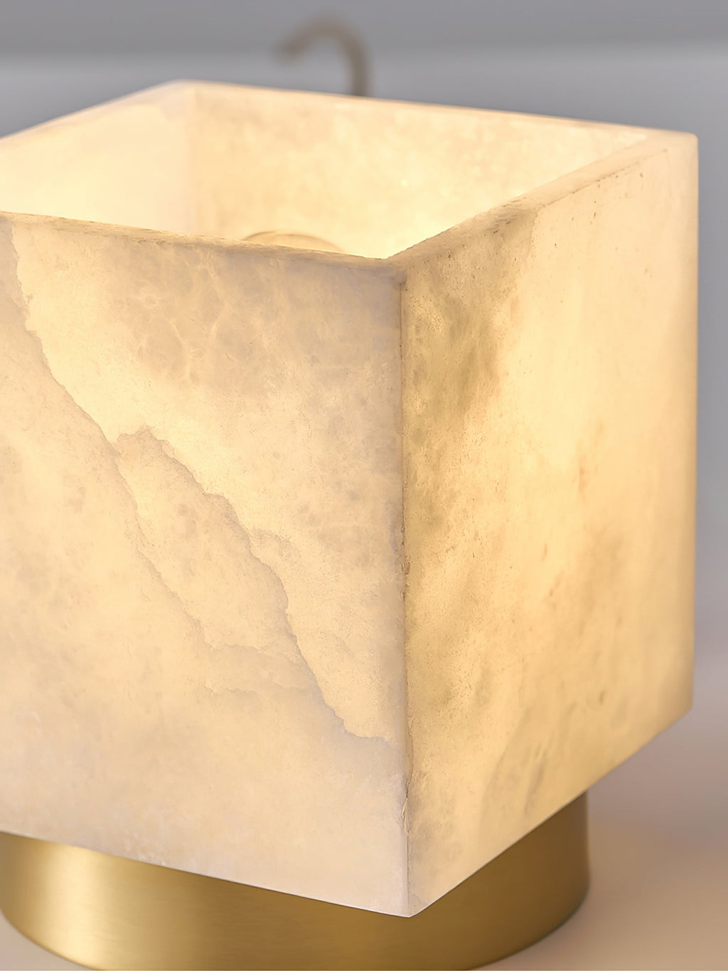 Close-up of the lit alabaster cube, showing the crystalline grain and cut edges of the natural stone shade.