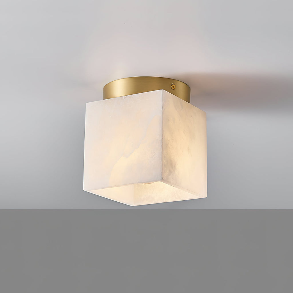 Usilia alabaster ceiling light switched on, the bulb glowing softly through the translucent stone from the side.
