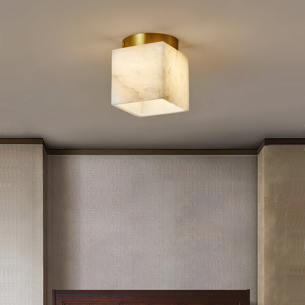 Usilia alabaster ceiling light lit above a textured silver-grey wall panel in a bedroom corner.