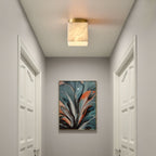 Usilia alabaster ceiling light lit in a narrow white corridor between two panelled doors.