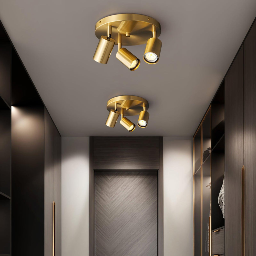 Brass spotlight ceiling light lit above a reading corner