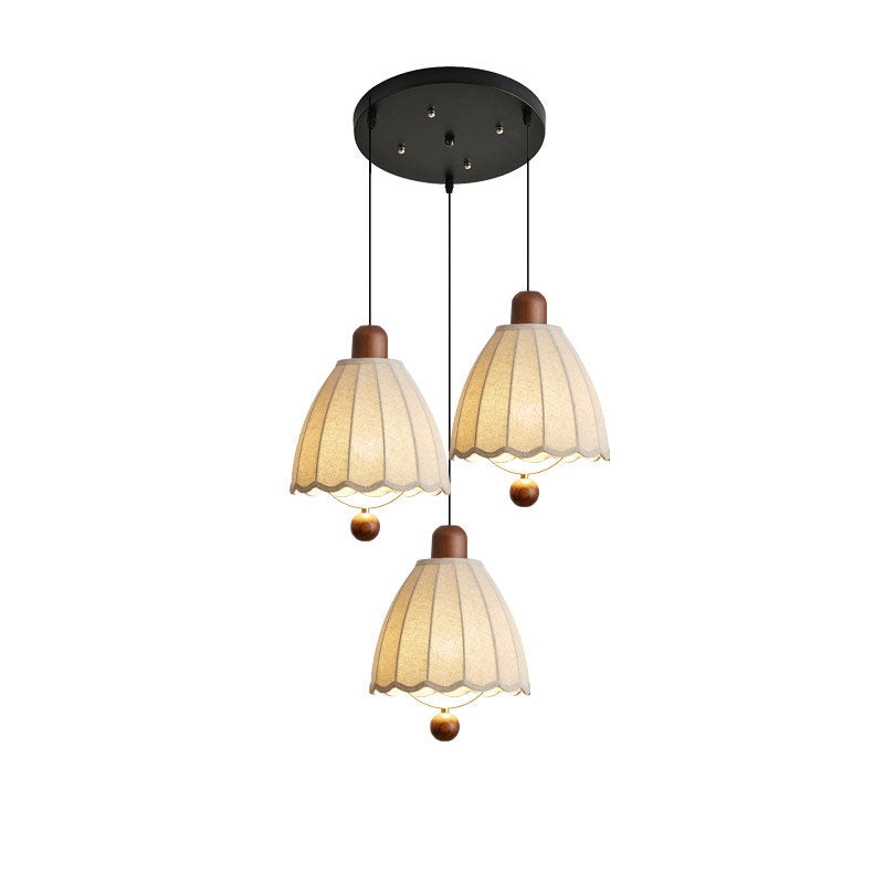 From a round ceiling plate, three of these Clérachic pendants hang at different lengths against white.