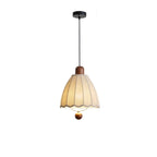 Product view of this Clérachic pendant's fluted shade and wood cap, hanging from a black canopy.
