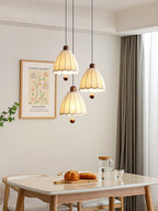 Three of these Clérachic pendants cluster at staggered heights near a table set with a cutting board and jug.