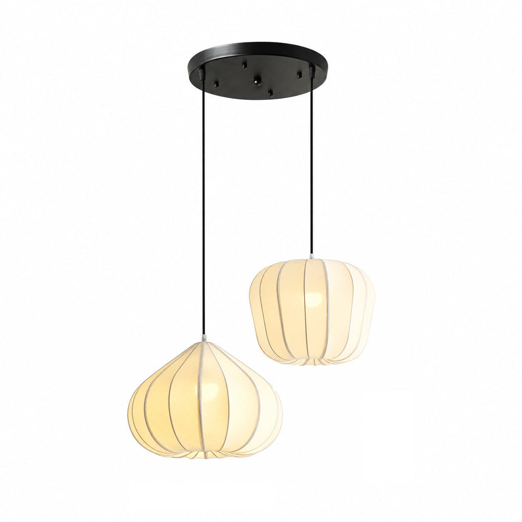 This two-head Clérachic pendant hangs from a black canopy, pairing a tapering black-seamed shade with a rounded one, both lit warm on white.
