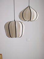 Two Clérachic pendant shades, one rounded and one tapering, hang unlit against a plain grey background.