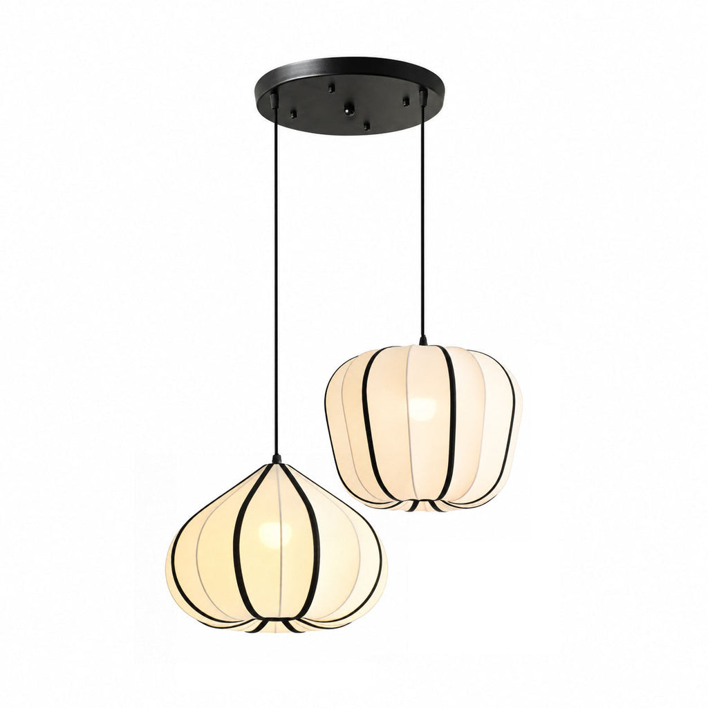 Two Clérachic pendant shades, one tapering and one rounded, hang at different heights from a shared black canopy, both glowing warm.