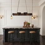 Rust finished industrial chandelier with Edison bulbs against a wall