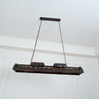 Rust iron Edison chandelier casting amber light in a bar setting