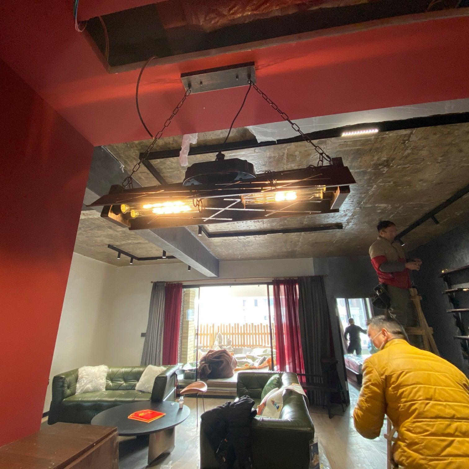 Linear industrial chandelier with amber Edison bulbs in rust finish