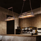 Rust iron linear chandelier glowing with warm amber Edison bulbs
