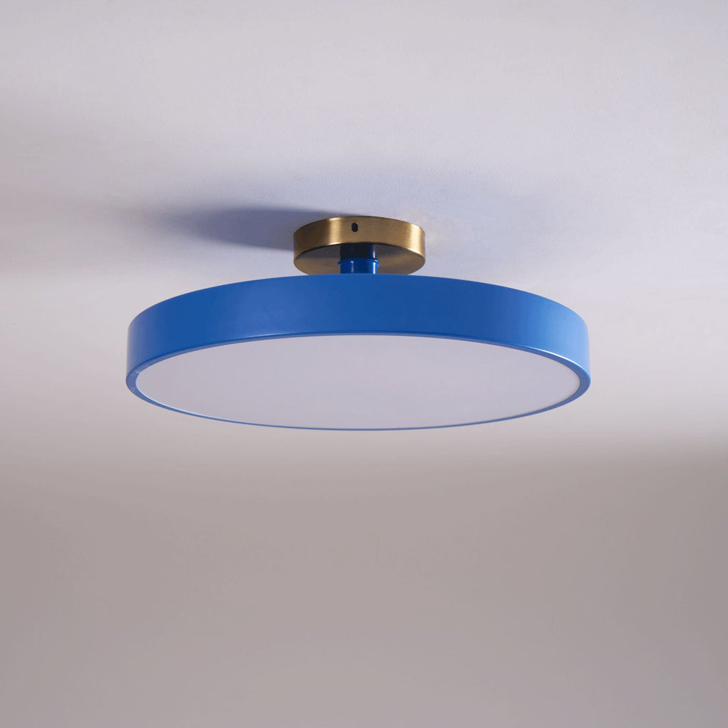 Flush mount ceiling light lit warmly over a dining space