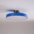 Flush mount ceiling light lit warmly over a dining space