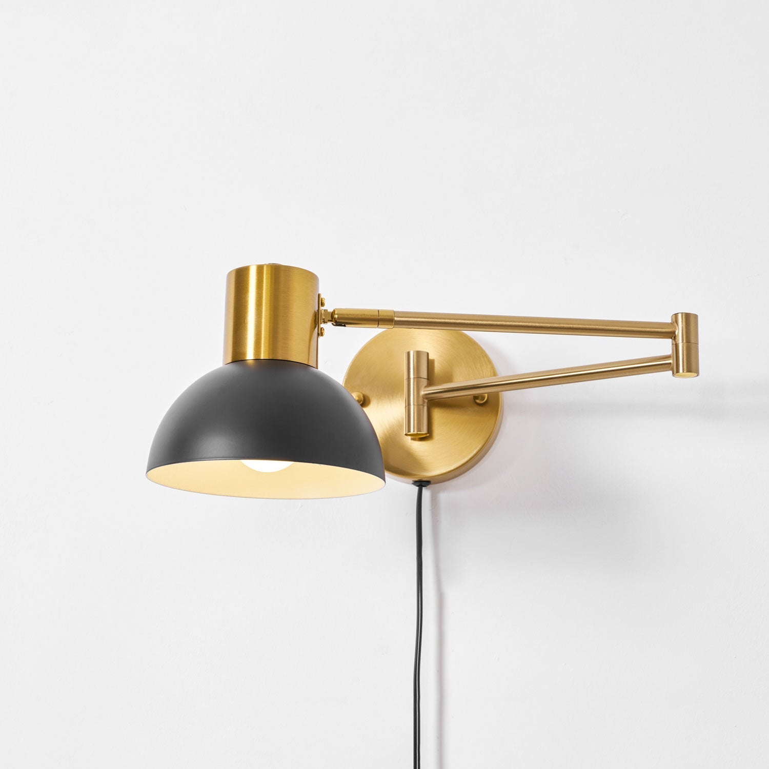 Swing arm wall lamp styled in a warm reading corner