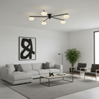 Black multi-arm ceiling light with sculptural white glass ovals