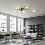 Black ceiling light with white oval shades over a seating area
