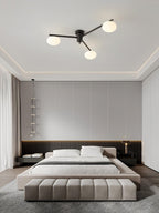 Brass ceiling light with white oval glass shades lit in a room