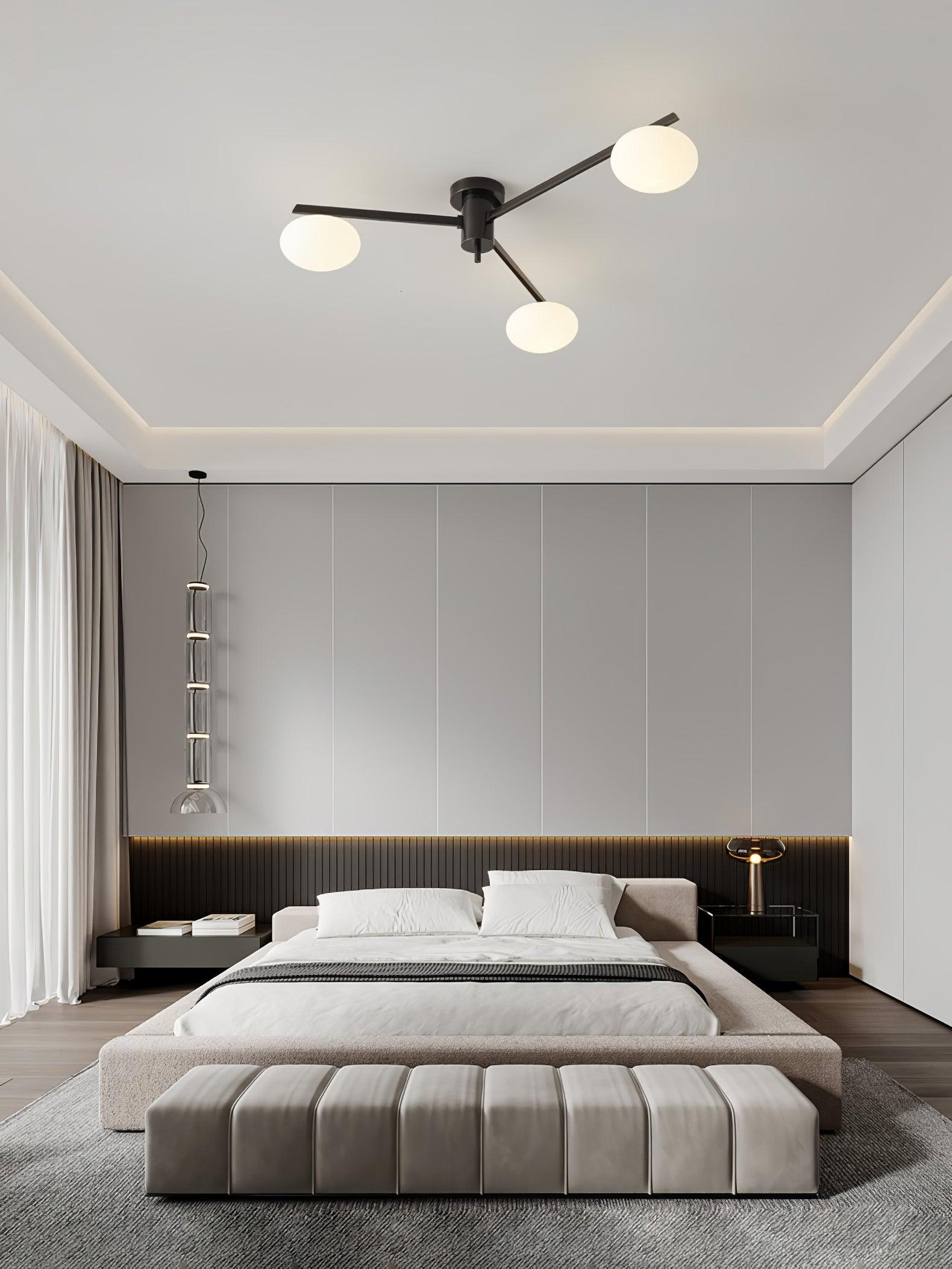 Brass ceiling light with white oval glass shades lit in a room