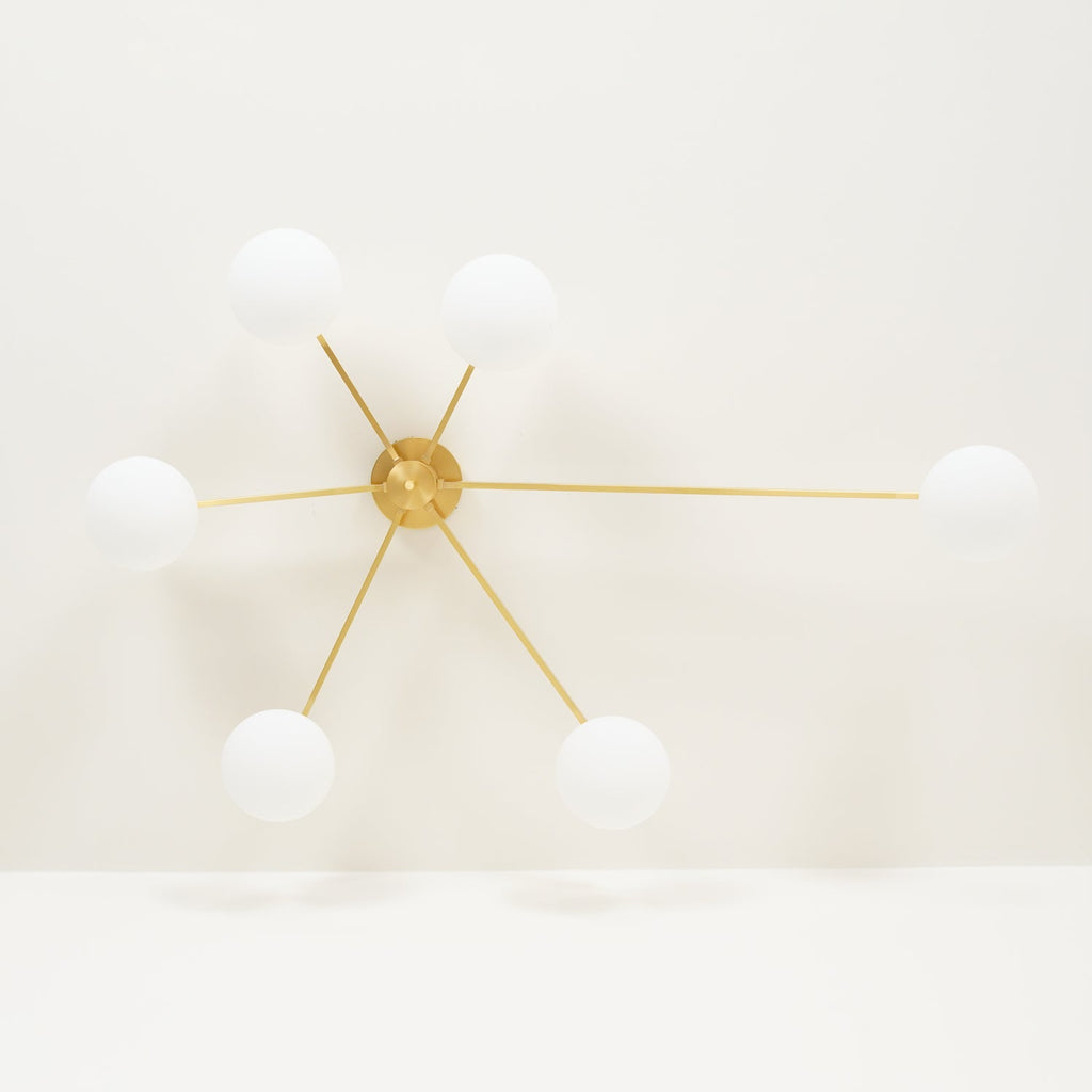 Multi-arm ceiling light with brass body and white oval glass shades