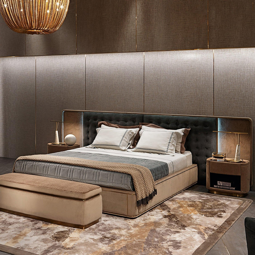 A wider bedroom view shows the Clérachic table lamp glowing on the nightstand, with a storage bench and patterned rug at the foot of the bed.