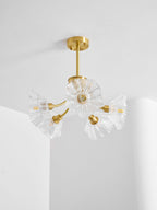 Ruffled glass shades sit close together on this Clérachic chandelier, hung in a corner near a sheer curtain.