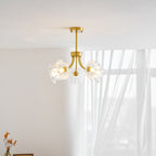 Sunlight through a curtain catches the brass frame and petal shades of this Clérachic chandelier.