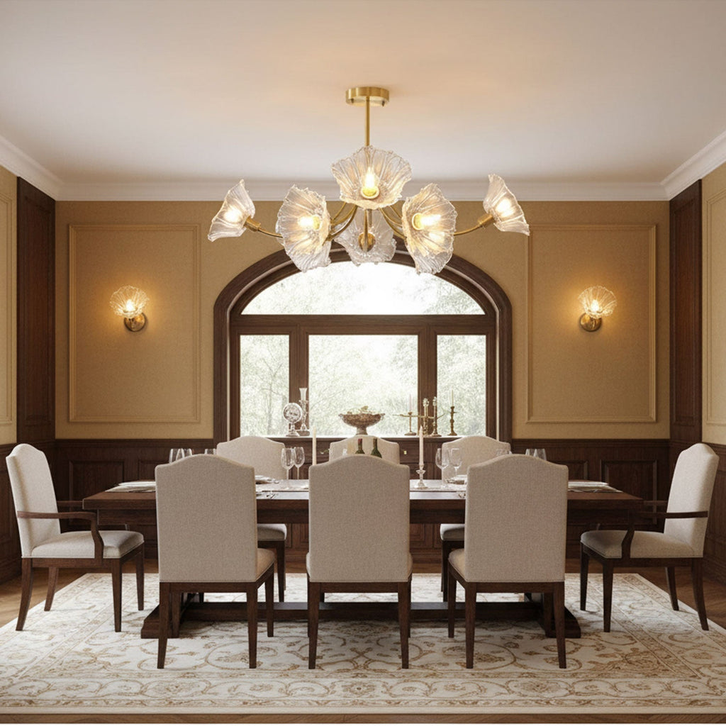 An arched window flanked by matching wall sconces sits behind this Clérachic chandelier, hung above a long dining table.