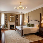 A four-poster bed and a lit fireplace sit beneath this Clérachic chandelier in a warmly furnished bedroom.