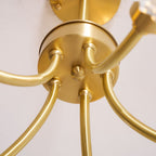 Close-up of the brass ceiling mount on this Clérachic chandelier, showing where its multiple arms converge.
