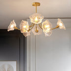 A side angle against plain grey walls shows this Clérachic chandelier's brass arms fanning out with clear glass petal shades.