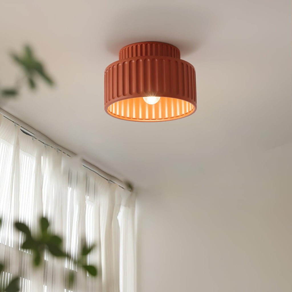 Pleated resin ceiling light with white rim glowing in a hallway