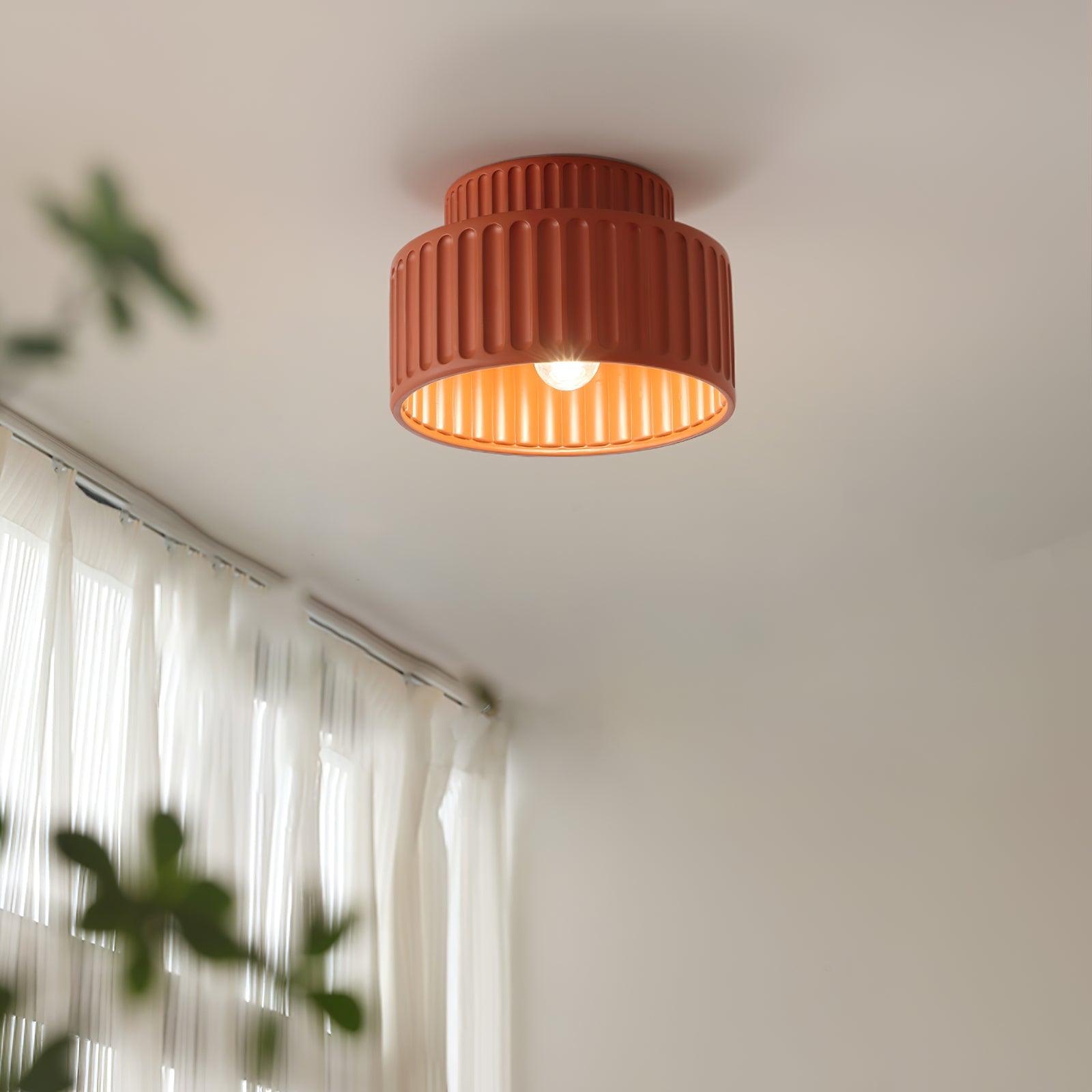 Pleated resin ceiling light with white rim glowing in a hallway