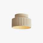 Pleated resin ceiling light glowing softly over a corridor