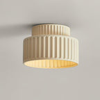 Pleated resin ceiling light with textured shade lit warmly