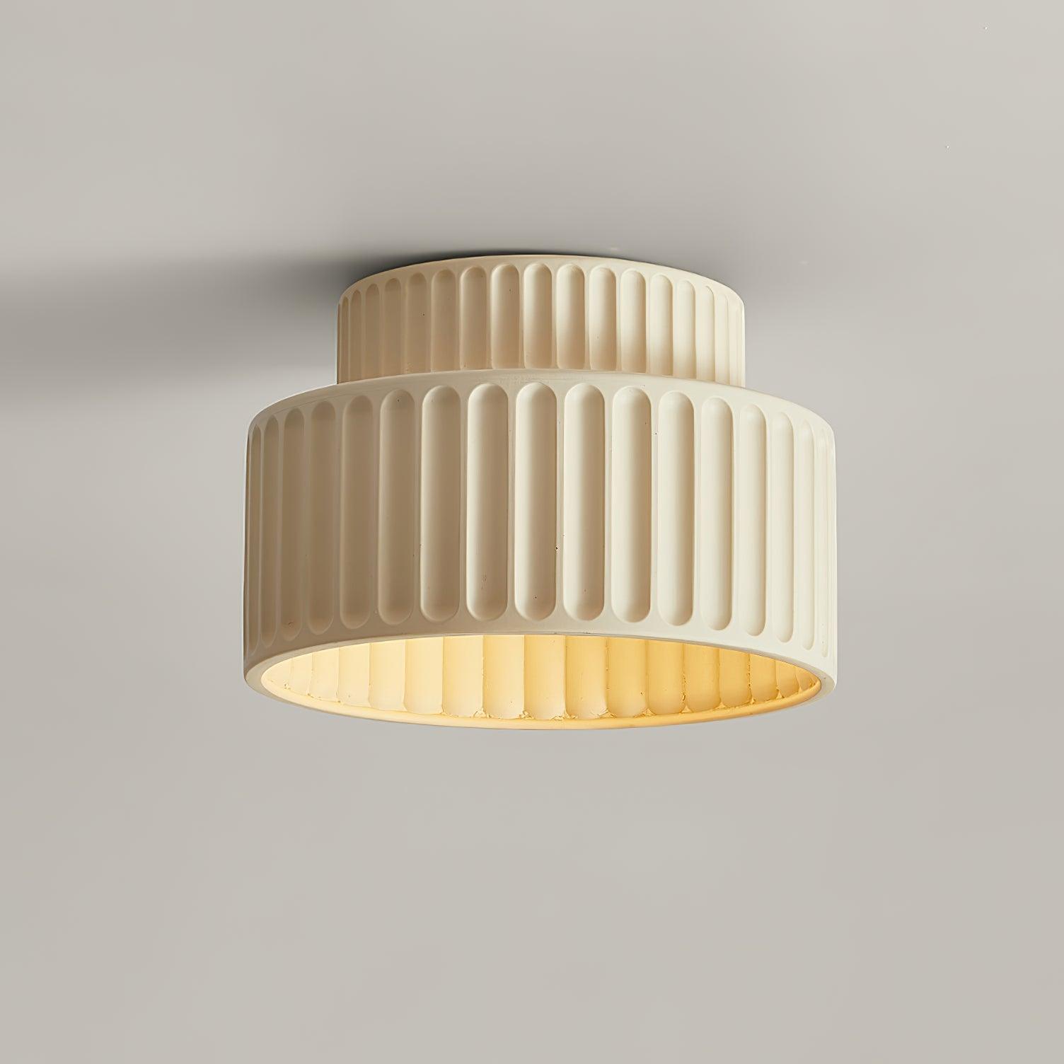 Pleated resin ceiling light with textured shade lit warmly