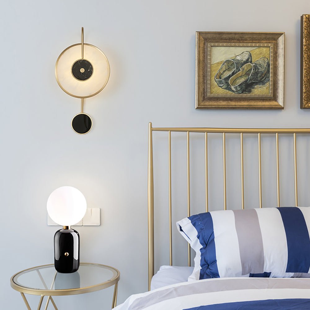 Lit in a blue bedroom beside a brass bed frame, a framed still life on the wall above.