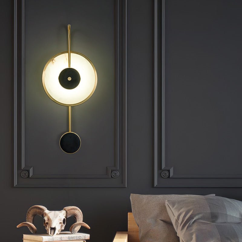 Lit on a dark grey panelled wall above a bed, a ram skull ornament on the shelf below.