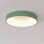 White flush mount ceiling light lit softly in a bedroom