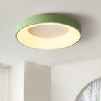 Round flush mount ceiling light lit warmly in a living room