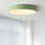 White flush mount ceiling light lit softly above a space