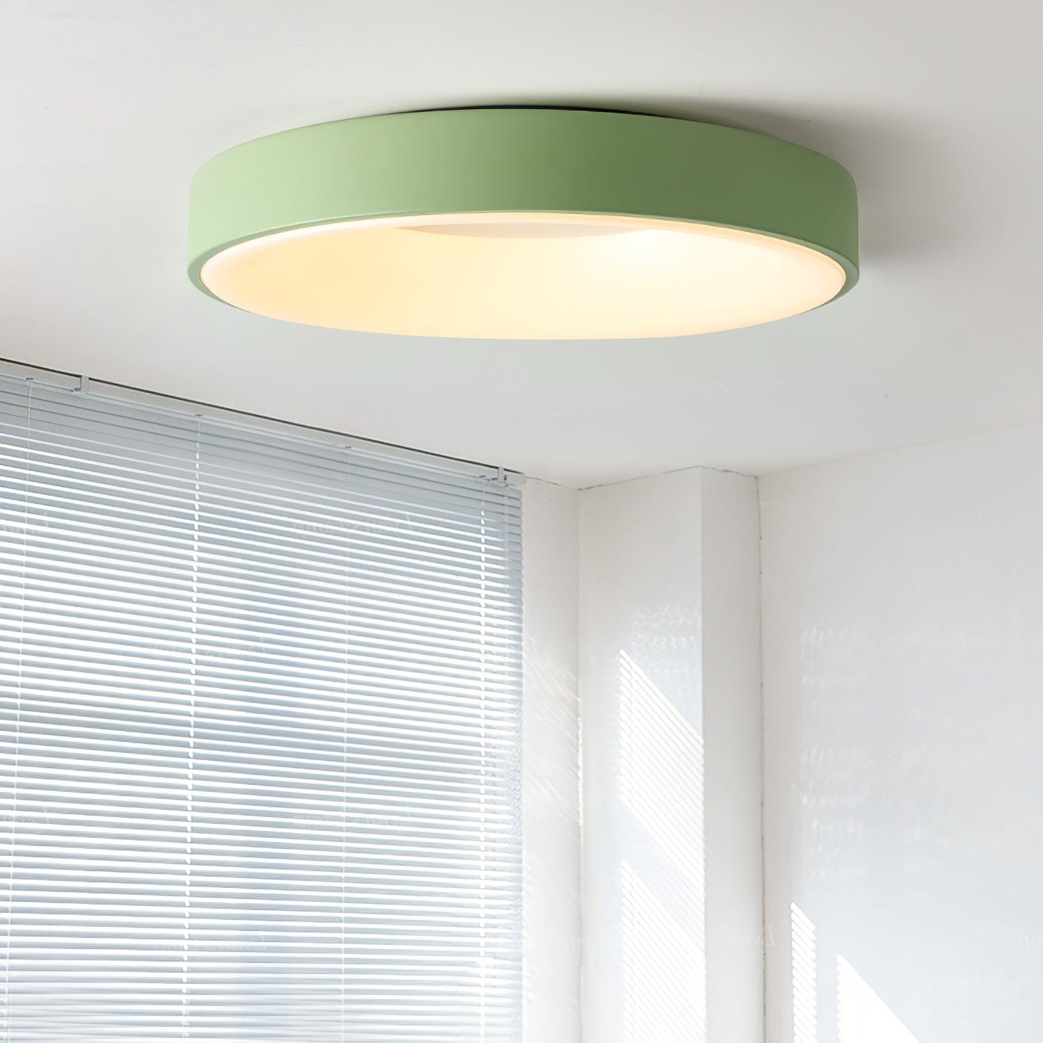 White flush mount ceiling light lit softly above a space