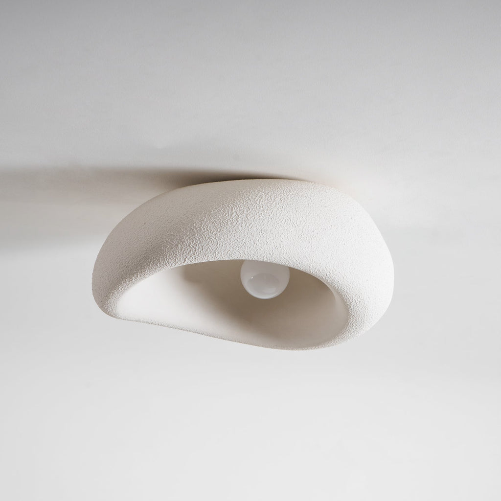 Close view of this Clérachic ceiling light with its bulb sitting unlit beneath the textured shade.