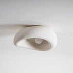 Close view of this Clérachic ceiling light with its bulb sitting unlit beneath the textured shade.