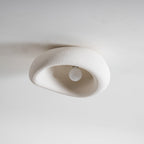 Shown from the front with its plain white bulb visible, this Clérachic ceiling light is unlit against a grey background.
