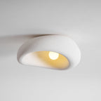 The bouclé-like texture of this Clérachic ceiling light is lit around a glowing bulb, plain grey background.