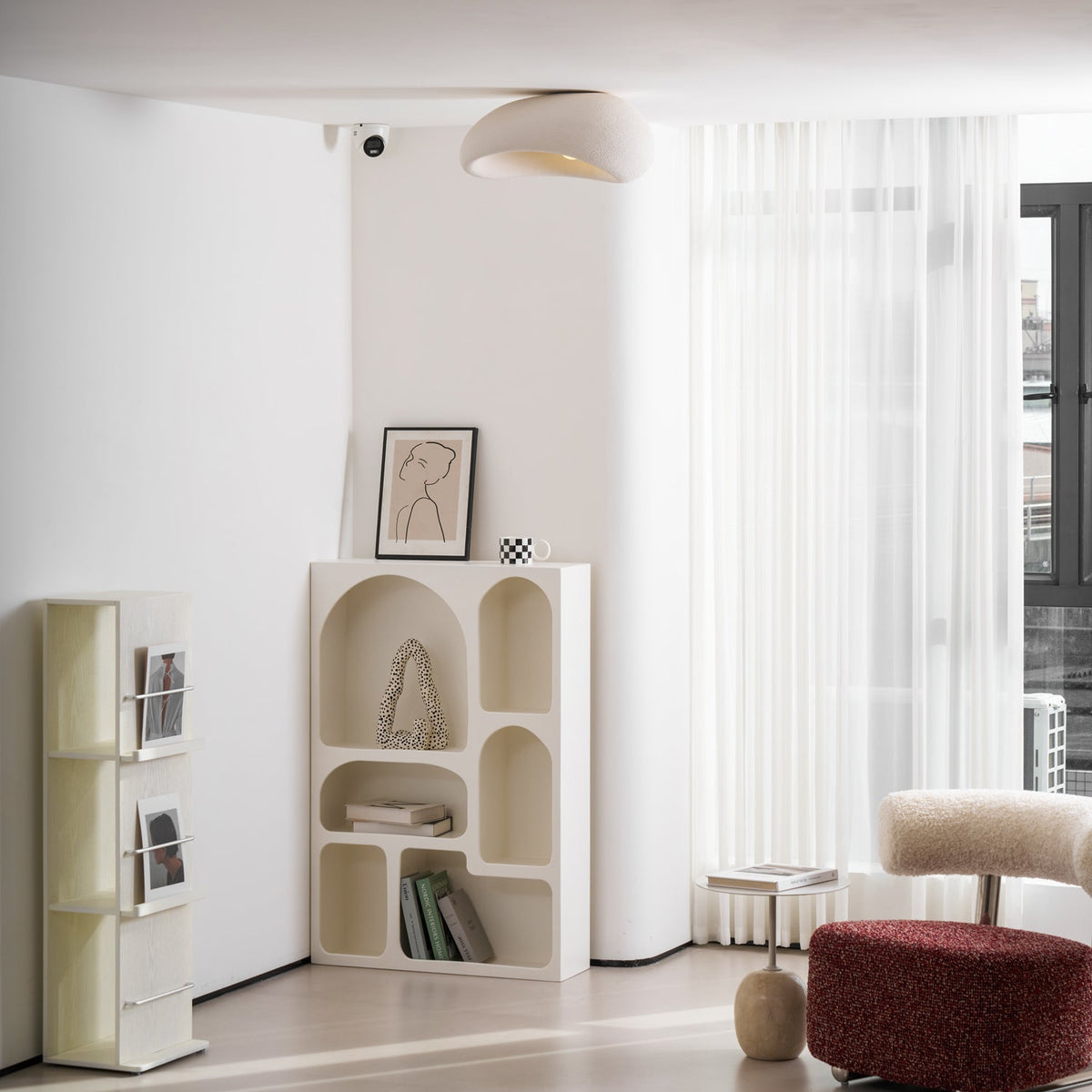 A wider view shows this Clérachic ceiling light lit near sheer curtains, with a red ottoman visible in the room.