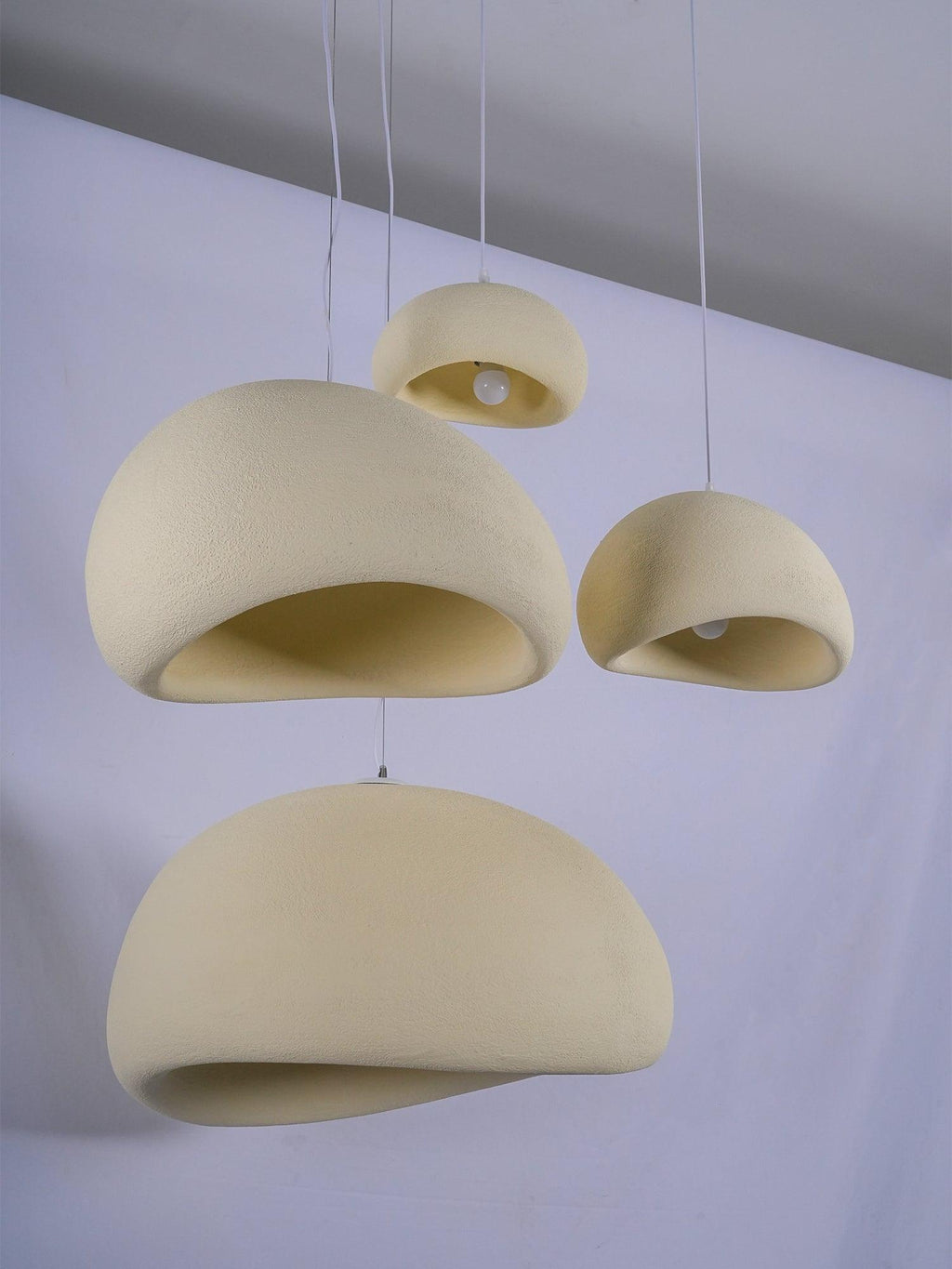 Wabi-sabi organic chandelier pendant lit with a warm globe
